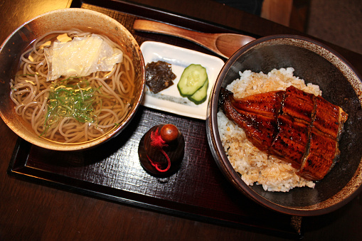 Unagi Kabayaki, eel grilled on rice and soba noodles and some pickles in a set meal at Japanese restaurant in Kyoto, Japan