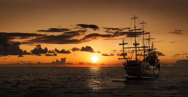 silhouette de bateau de pirate - yacht sea sunrise sailing photos et images de collection