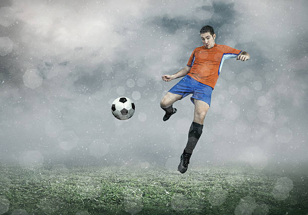 istock Football player with ball in action under sky with clouds 545279044