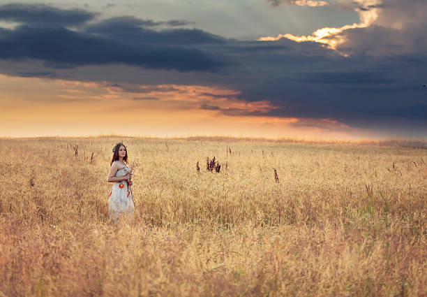 istock Young woman in a wheat field at sunset 545281428