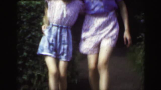 1949: Sisters dancing outdoor garden blond caucasian girls enjoying summer.