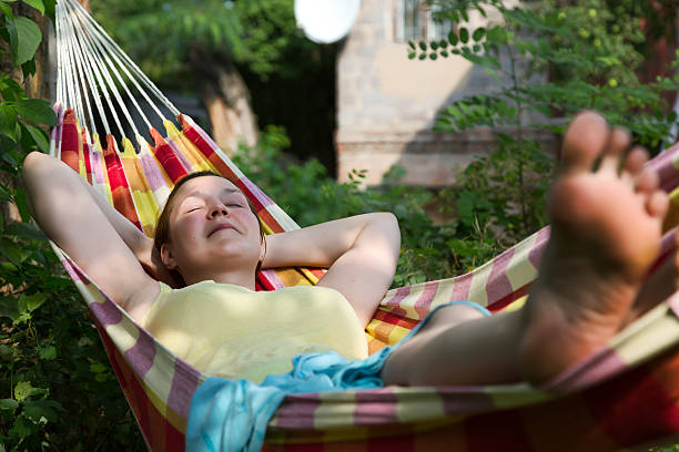 istock Person relaxing in Hummock at Summer Garden 545337382