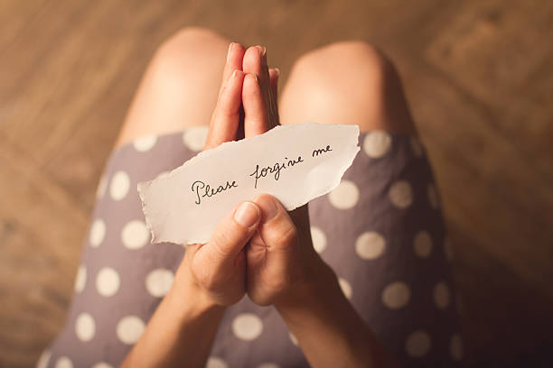 istock Woman holding a paper with text please forgive me 545338730