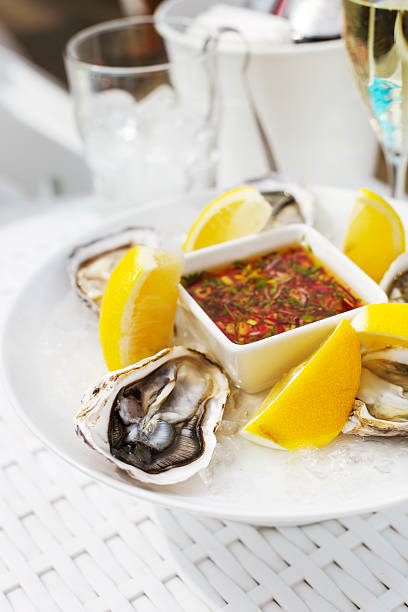 istock Fresh oysters shell with lemon and glasses of champagne. 545339262