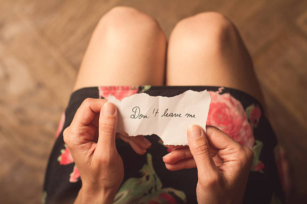 istock Woman holding a note with do not leave me 545340136