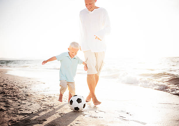 istock Father Son Playing Soccer Beach Summer Concept 545341166