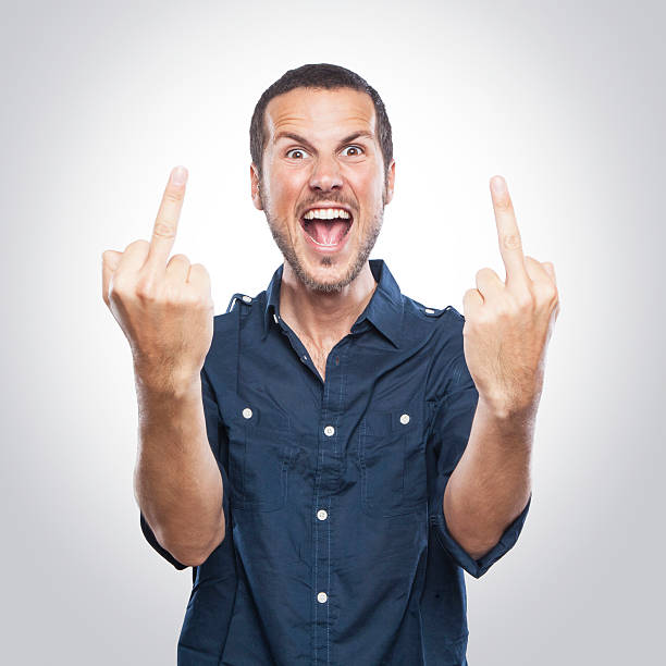 handsome young man showing middle finger handsome young man showing middle finger, insult signhandsome young man showing middle finger, insult sign with funny face expression irony stock pictures, royalty-free photos & images