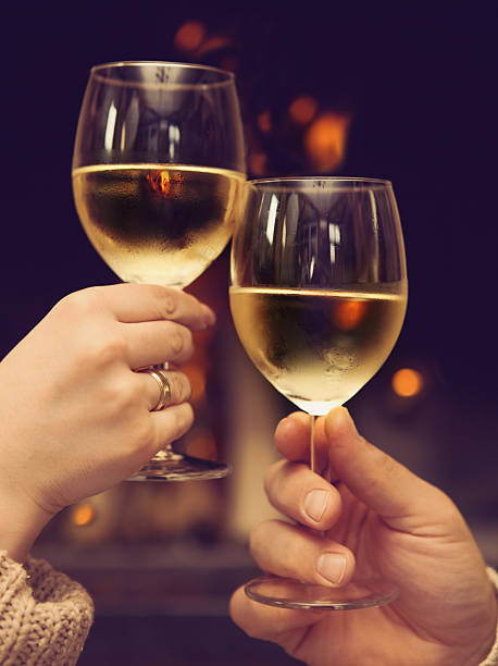 istock Couple toasting wineglasses in front of lit fireplace 545347266