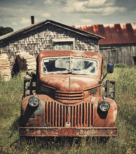 Forties Farm Truck A 1940's one tonne pick up truck sits outside a small cabin in afternoon sunlight. old truck stock pictures, royalty-free photos & images