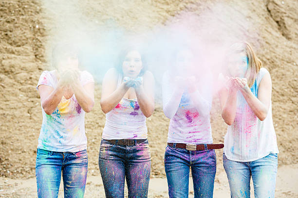 istock Four women blowing colors from hands 545349552