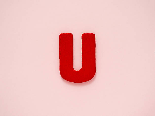 istock Red letter U from wood on pink background. Alphabet vowel. 545350818
