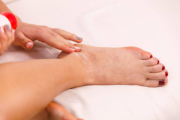 istock Woman putting ointment on bad ankle applying cream 545354862