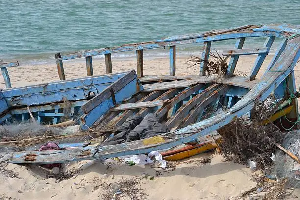 Wooden boatwreck on a shore.