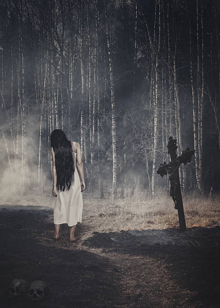 istock Ghost on the road to dark Halloween forest 545359406