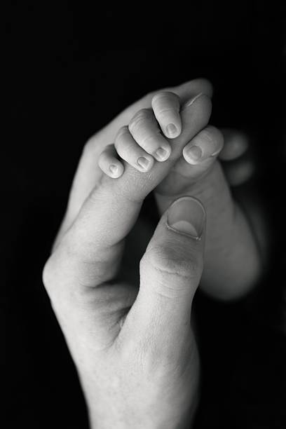 istock Newborn Gripping Dad's Finger 545359490