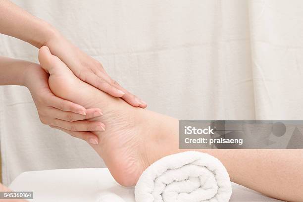 Foot Massage Therapists Hands Massaging Female Foot Stock Photo - Download Image Now