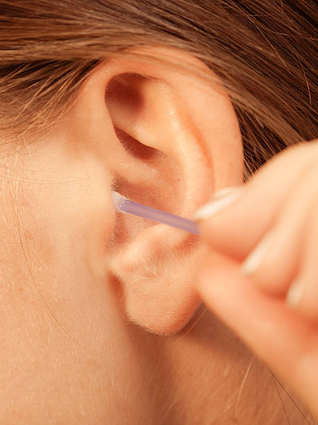 istock Woman cleaning ear with cotton swabs closeup 545360310