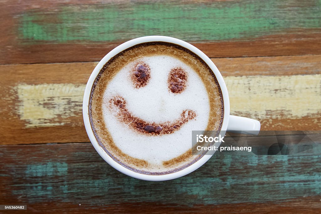 Smile face drawing on latte art coffee , wood color background Coffee - Drink Stock Photo