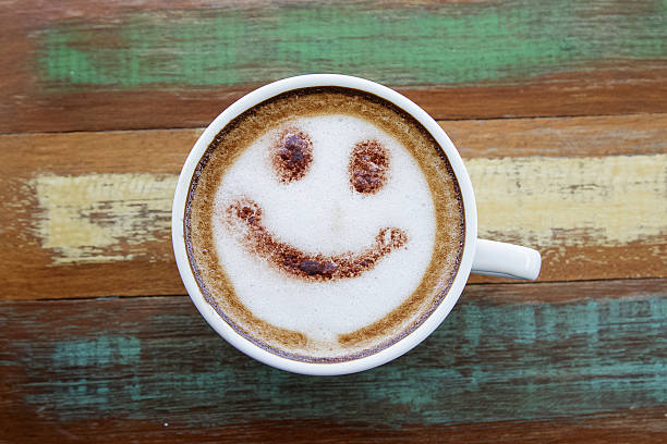Smile face drawing on latte art coffee , wood color background Smile face drawing on latte art coffee , wood color background coffee break photos stock pictures, royalty-free photos & images