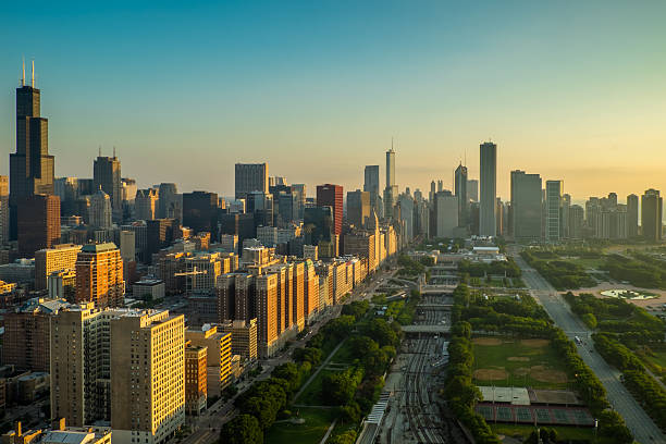 Chicago Golden Morning The heart of the City of Chicago receiving the first golden rays of sun on a summer morning. You can see one of the tallest buildings in Chicago (Willis Tower) highlighted on the left side of the photo. millennium park chicago stock pictures, royalty-free photos & images