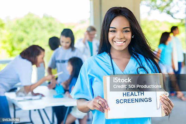 Beautiful African American Woman Holding A Free Health Screenings Sign Stock Photo - Download Image Now