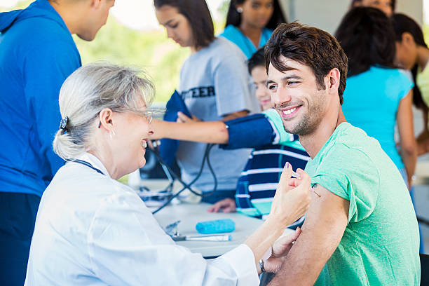 istock Handsome patient smiling at doctor during vaccination 545361842