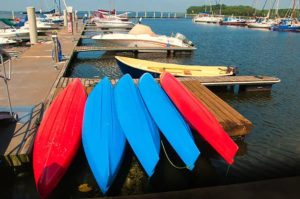 Colorful small boats stacked along wooden pier