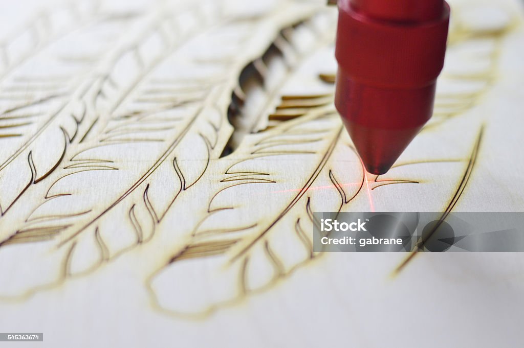 Laser cutting machine Laser cutting machine cutting plywood feathers. Engraving Stock Photo