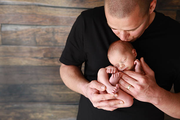 istock Dad Kissing Newborn Son 545363922