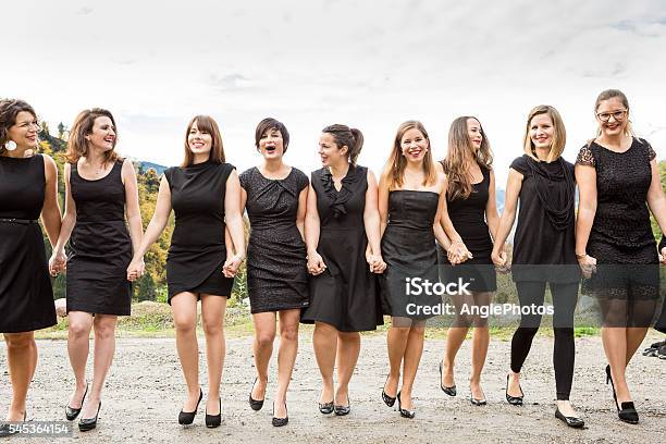 Group Of Women In Black Dress Walking Hand In Hand Stock Photo - Download Image Now - Holding Hands, In A Row, Only Women