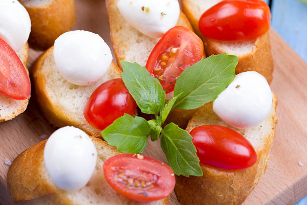 Caprese sandwiches of mozzarella cheese, tomato and basil Caprese sandwiches of mozzarella cheese, tomato and basil on a table sandwich new hampshire stock pictures, royalty-free photos & images