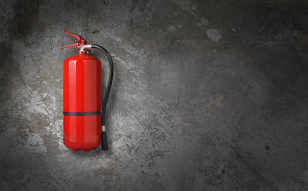 fire extinguisher fire extinguisher on gray wall fire extinguisher photos stock pictures, royalty-free photos & images