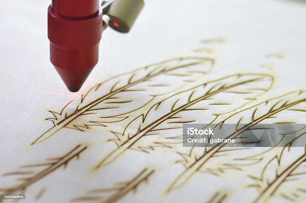 Laser cutting machine Laser cutting machine cutting plywood feathers. Laser Stock Photo