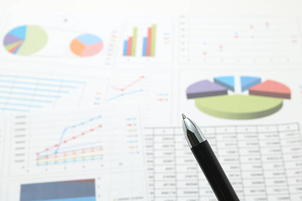 istock Pen in front of papers with numbers and charts. 545372056