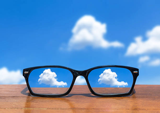 istock eyeglasses on wooden table front abstract white clouds on blue sky 545372646
