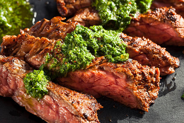 Homemade Cooked Skirt Steak with Chimichurri Homemade Cooked Skirt Steak with Chimichurri Sauce and Spices chimichurri stock pictures, royalty-free photos & images