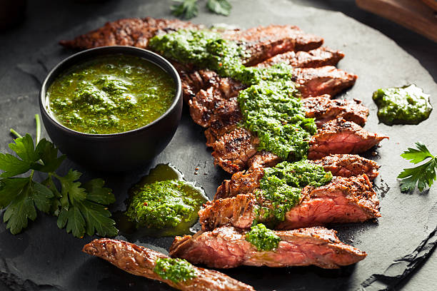 Homemade Cooked Skirt Steak with Chimichurri Homemade Cooked Skirt Steak with Chimichurri Sauce and Spices marinated photos stock pictures, royalty-free photos & images