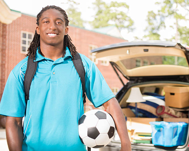 istock African-descent boy moves into college. Packed car.  School campus. 545373938