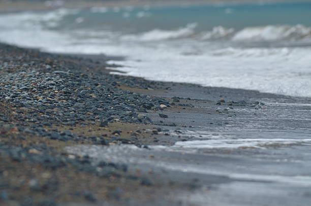 istock Low level view of waves and surf on pebbly beach 545374884