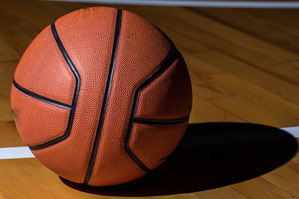 istock Basketball isolated on court black background with light effect 545377278