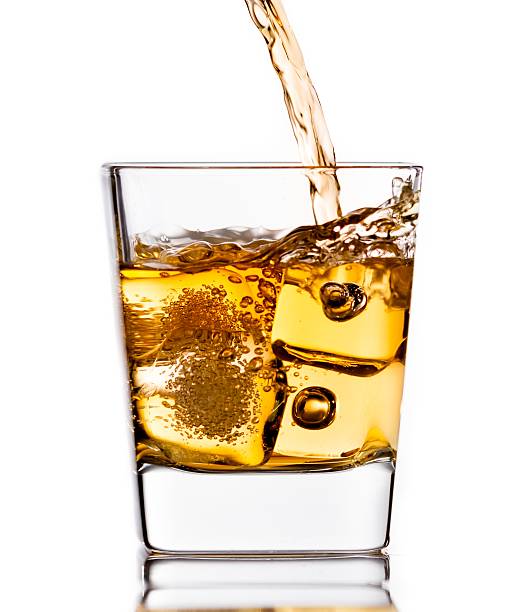 istock pouring scotch whiskey in glass with ice cubes on white 545425760