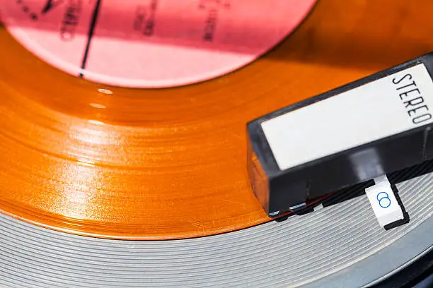 Photo of above view of headshell on orange vinyl record