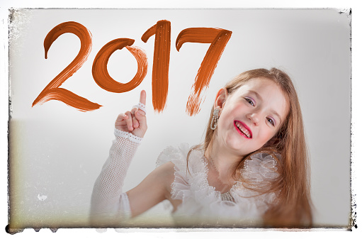 Little girl pointing at 2017 on window