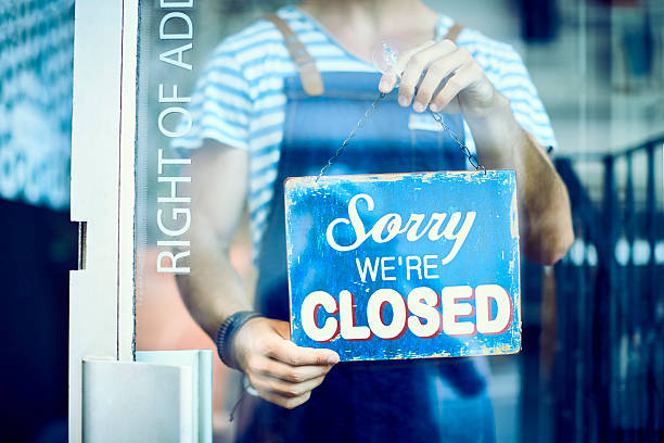 istock Midsection of barista holding closed sign at window 545434094
