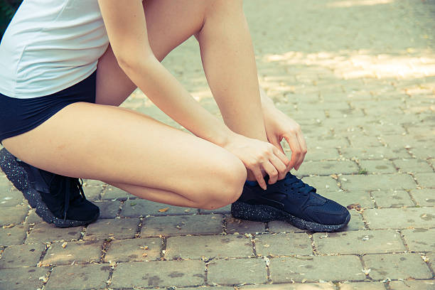 istock young woman tying shoelace 545438734