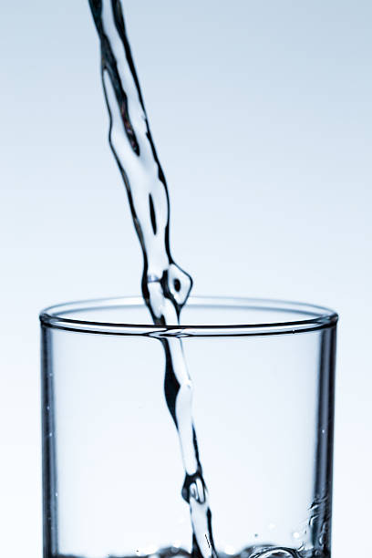 istock pouring water into glass 545439420