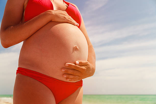 istock Happy pregnant woman at beach 545439780