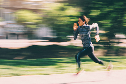 A woman running outside in the  city.