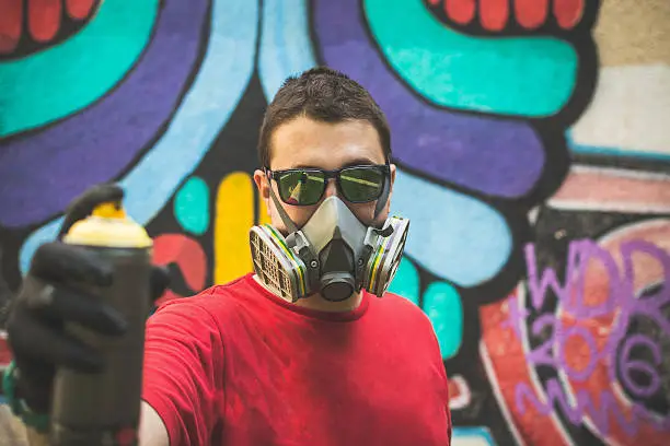 Photo of Graffiti artist holding spray color can