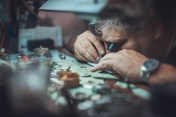 watchmaker repairing watch at his workshop .